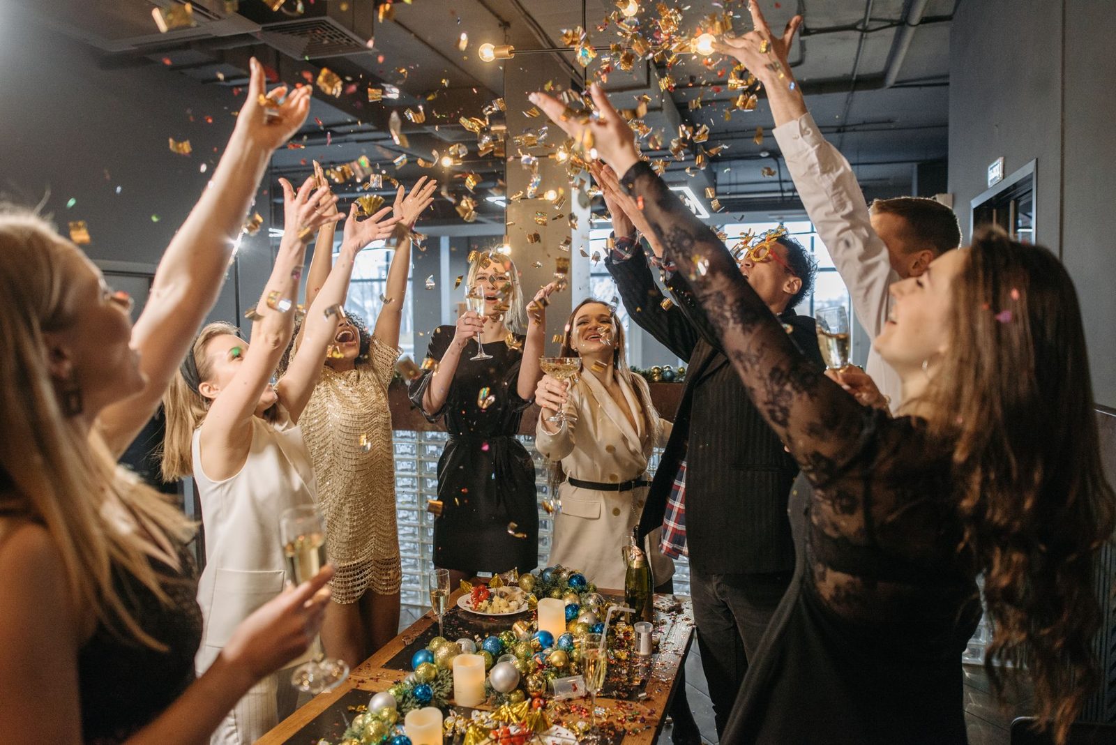 Friends celebrating together, throwing gold confetti in the air