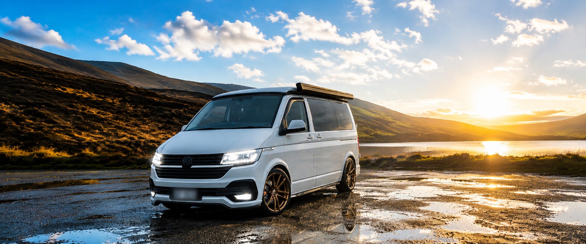 White van with its headlights on, parked by a lake in the hills at sunset, photo supplied by a HoldenTek customer